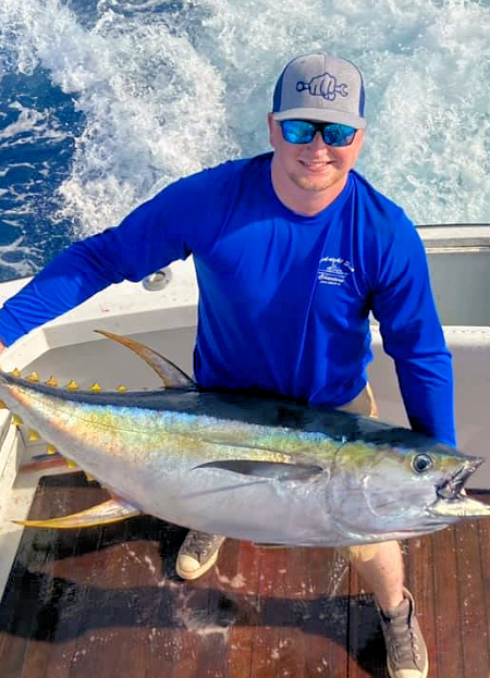 Very happy young man holding a beautifully colored large yellowfin tuna Angler holding large yellowfin tuna.
