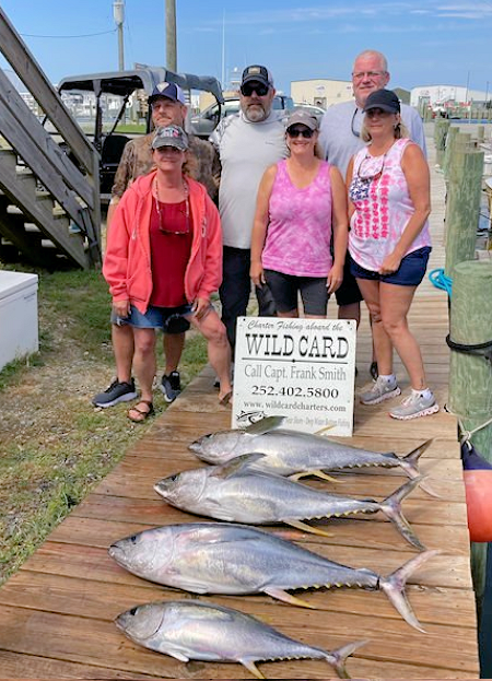 Vacationing family showing off their catch of big fat tuna. Family showing off catch of tuna.